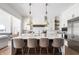 Stylish kitchen with a marble island, stainless steel appliances, and modern lighting fixtures at 11896 Spring Mill Rd, Carmel, IN 46032