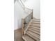 Elegant staircase with wood treads, contemporary railing and a decorative vase on landing at 11896 Spring Mill Rd, Carmel, IN 46032