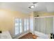 Bright bathroom featuring shuttered windows, a bathtub, and a glass-door shower at 232 N Church St, Morgantown, IN 46160