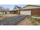 View of brick home featuring a long driveway leading to an attached garage at 232 N Church St, Morgantown, IN 46160