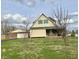 A yellow and brick home with a two-car garage and a nice lawn at 232 N Church St, Morgantown, IN 46160