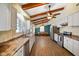 Bright kitchen with white cabinets, wood floors, and stainless steel appliances flowing into a dining area with bench seating at 232 N Church St, Morgantown, IN 46160