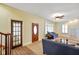 Sunlit living room featuring neutral carpet, plantation shutters, a ceiling fan, and comfortable seating at 232 N Church St, Morgantown, IN 46160