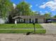 Charming single-story home featuring a well-maintained lawn, attached garage, and convenient carport at 6031 Wixshire Dr, Indianapolis, IN 46254