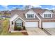Exterior view of home with brick accents, a well-manicured lawn, and attached garages at 1463 Hamilton Dr, Greenwood, IN 46143
