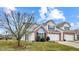 Exterior view of home with brick accents, a well-manicured lawn, and attached garages at 1463 Hamilton Dr, Greenwood, IN 46143