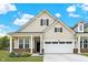 Charming home featuring a two-car garage, inviting front porch, and manicured lawn at 18425 Depoe Ln, Westfield, IN 46074