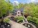 Aerial view of stately brick home, black roof, and beautiful lush surroundings at 9468 Sullivan Pl, Zionsville, IN 46077