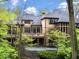 Spacious home exterior featuring stone patio, balcony, and mature trees at 9468 Sullivan Pl, Zionsville, IN 46077
