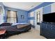 Comfortable bedroom featuring neutral carpet flooring, blue paint, and a large television at 719 Trent Dr, Greenwood, IN 46143