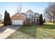 Inviting two-story home boasts a brick facade, covered porch, and well-manicured lawn at 719 Trent Dr, Greenwood, IN 46143
