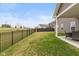 A well-maintained backyard featuring an iron fence, lush grass, and an inviting covered patio for relaxation at 8118 Ambrosia Ln, Pendleton, IN 46064