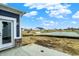 Backyard view, looking to the pond and other residences, with a grey patio area at 413 Onset Way, Westfield, IN 46074