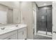 Bathroom featuring double vanity with white cabinetry and glass enclosed shower with gray tiling at 413 Onset Way, Westfield, IN 46074