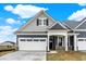 Charming two-story home featuring blue siding, a white garage door, and a covered front porch at 413 Onset Way, Westfield, IN 46074