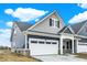 Side view of a stylish home with a white garage door, blue siding, and gray shingle accents at 413 Onset Way, Westfield, IN 46074