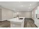 Open-concept kitchen featuring a large island with sink and stainless steel appliances and wood floors at 413 Onset Way, Westfield, IN 46074