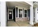 Inviting covered porch with a black front door, white columns, and brick accents at 413 Onset Way, Westfield, IN 46074