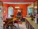 Country style eat-in kitchen featuring wooden table/chairs, tile floors, and vibrant orange walls at 3305 N Keystone Ave, Indianapolis, IN 46218