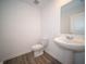 A half bath with a pedestal sink and a comfort height toilet, next to the home's entry at 1217 Fleming Dr, Greenfield, IN 46140