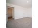 Neutrally decorated bedroom with white walls, gray carpet, and a door leading to another room at 1217 Fleming Dr, Greenfield, IN 46140