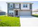 Charming two-story home featuring a manicured lawn, two-car garage, and welcoming front door at 1217 Fleming Dr, Greenfield, IN 46140