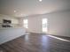 Open-concept living room and kitchen showcases hardwood floors and an exit door at 1217 Fleming Dr, Greenfield, IN 46140