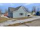 Side view of charming blue house with gray door, showcasing curb appeal at 405 E 9Th St, Sheridan, IN 46069