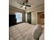 Cozy bedroom with a sliding barn door, ceiling fan, and large window at 4143 Graceland Ave, Indianapolis, IN 46208