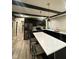 Modern kitchen with stainless steel appliances, marble countertop island, and sleek black cabinetry at 4143 Graceland Ave, Indianapolis, IN 46208