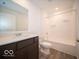 Bathroom with a tub, toilet, vanity, and dark brown cabinets at 6036 Card Blvd, Indianapolis, IN 46221
