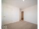 Spacious bedroom with carpeted floors and an adjacent hallway at 6036 Card Blvd, Indianapolis, IN 46221