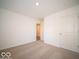 Bedroom with carpeted floors, neutral walls, and a door to the hallway at 6036 Card Blvd, Indianapolis, IN 46221