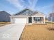 Brick house with gray siding, a two-car garage, and a covered porch at 6036 Card Blvd, Indianapolis, IN 46221