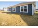 Home's rear elevation showcases blue siding and a spacious yard at 6036 Card Blvd, Indianapolis, IN 46221
