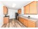Well-lit kitchen featuring wood cabinets, modern appliances, and hardwood floors at 12912 Broncos Dr, Fishers, IN 46037