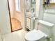 This bright bathroom features white beadboard walls, compact sink and fixtures, and modern toilet at 335 N Grant Ave, Indianapolis, IN 46201