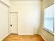 This bright bedroom features wood floors, neutral walls, and natural light from a window at 335 N Grant Ave, Indianapolis, IN 46201