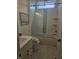 Well-lit bathroom featuring shower/tub combo with glass doors, light colored tile, and a decorative swan picture at 947 W 146Th St, Carmel, IN 46074