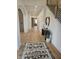 Bright foyer features wood floors, decorative rug, console table, and staircase with black iron railings at 947 W 146Th St, Carmel, IN 46074