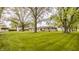 Spacious backyard with a lush green lawn, mature trees, and detached garage, offering a serene outdoor space at 5861 S 100 W, Fountaintown, IN 46130