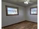 A bright bedroom features hardwood floors and two windows bringing in ample natural light at 5861 S 100 W, Fountaintown, IN 46130