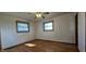 An additional view of the bedroom reveals hardwood floors, two windows, and a ceiling fan at 5861 S 100 W, Fountaintown, IN 46130