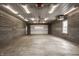 Spacious garage with concrete floor, block walls, overhead lighting, and door to the exterior at 5861 S 100 W, Fountaintown, IN 46130