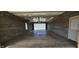 Inside the block garage with concrete flooring, showing ample space and natural light from the open door at 5861 S 100 W, Fountaintown, IN 46130