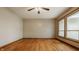 Light-filled room showcasing beautiful hardwood flooring, ceiling fan, and large window overlooking the yard at 5861 S 100 W, Fountaintown, IN 46130