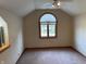 This bedroom is carpeted and features a vaulted ceiling, baseboard trim, and an arched window at 6640 Greenridge Dr, Indianapolis, IN 46278