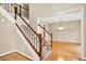 Welcoming entryway with hardwood floors and a staircase featuring wood railings and carpeted steps at 6640 Greenridge Dr, Indianapolis, IN 46278