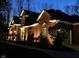 Night view of a charming brick home with manicured landscaping and welcoming illumination at 6640 Greenridge Dr, Indianapolis, IN 46278