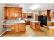 Large kitchen with wood cabinets, hardwood floors, a center island, and black appliances at 6640 Greenridge Dr, Indianapolis, IN 46278